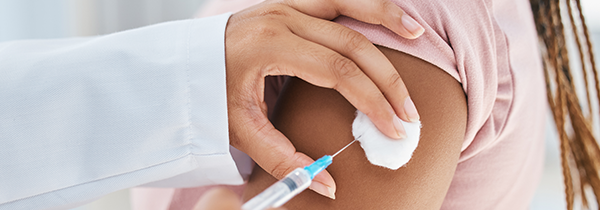 person receiving vaccination in healthcare setting with focus on arm and syringe promoting health for individuals aged 18 and older